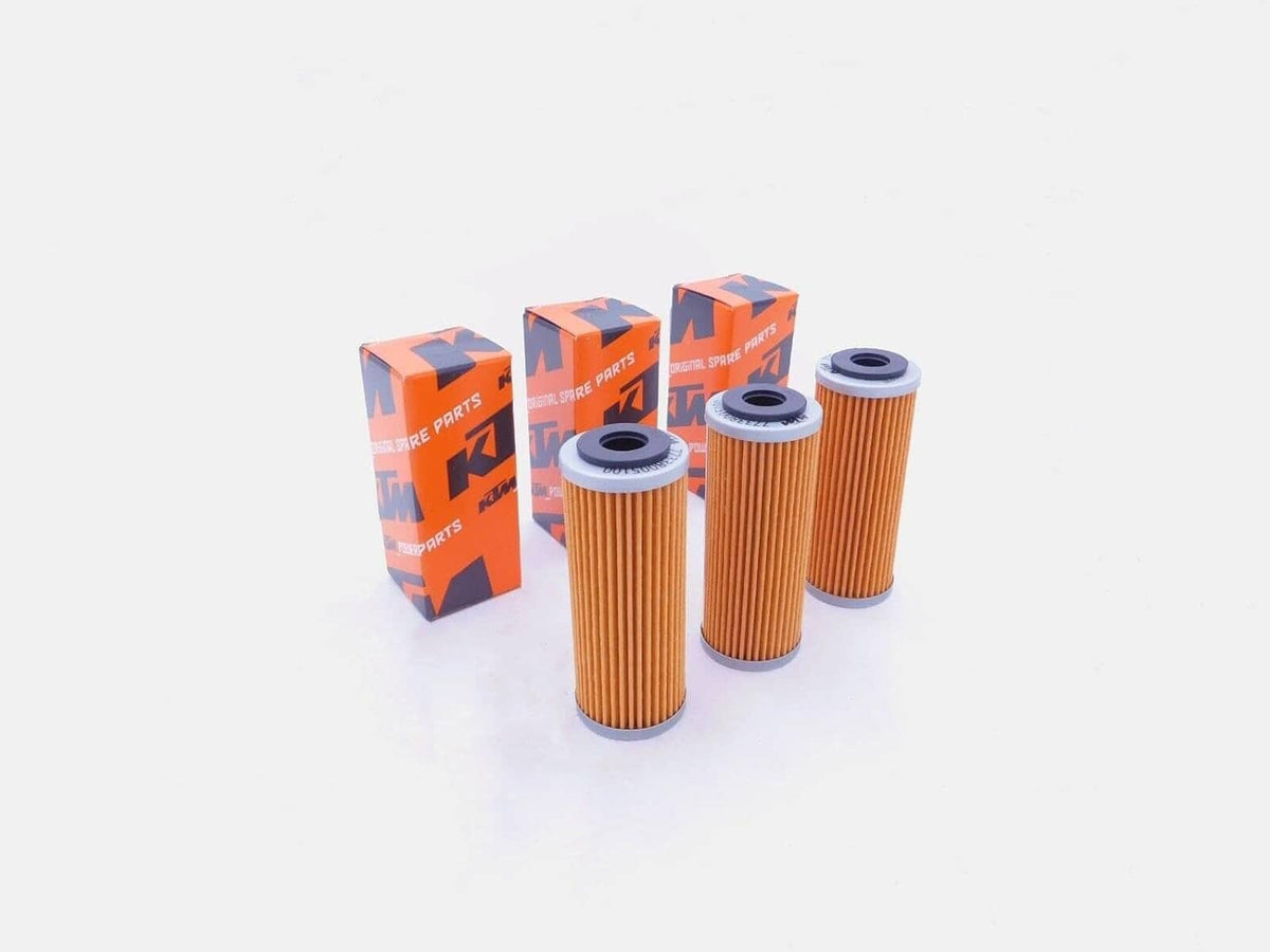Three orange KTM oil filter cartridges with black end caps and three boxes