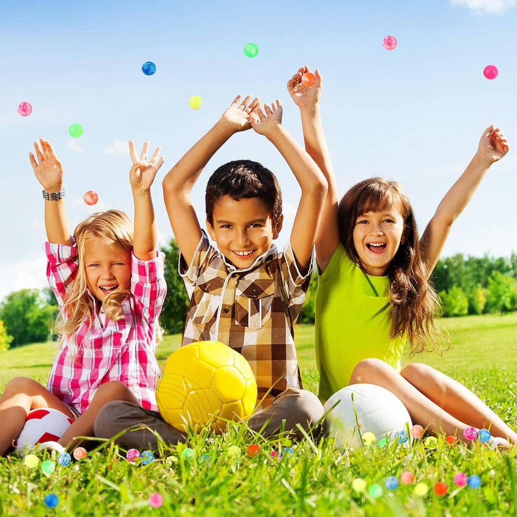 Colorful bouncy balls floating above kids during outdoor play, mixed marbled colors.
