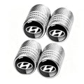 Set of four silver textured tire valve stem dust caps with black Hyundai-style logo face.