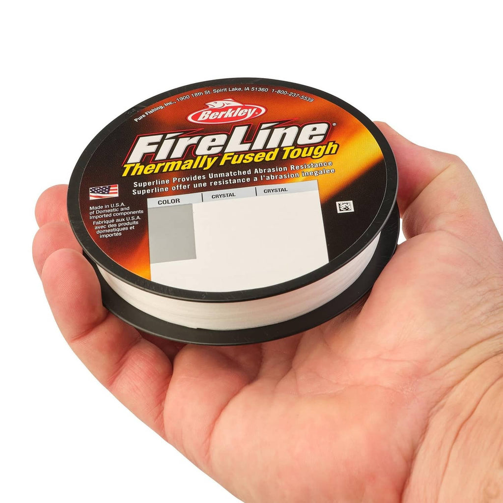 Thermally Fused Tough crystal fishing line spool held in a hand with white line
