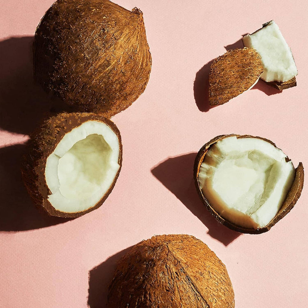 Coconut butter scrub with coconut halves and flakes for exfoliating body care
