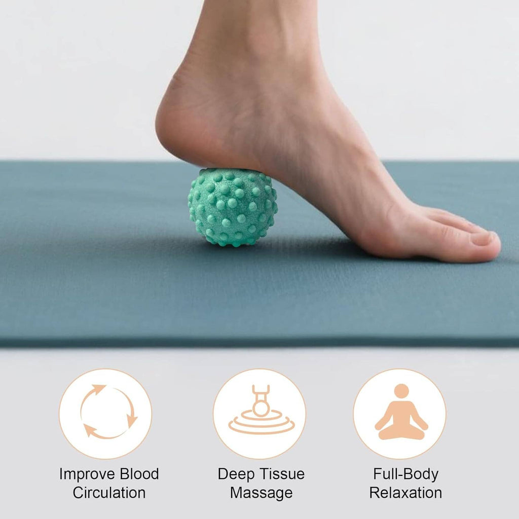 Teal foot massage ball with nubs under the foot on a blue exercise mat