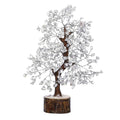 Clear quartz crystal tree decoration with silver branches on a round wooden base