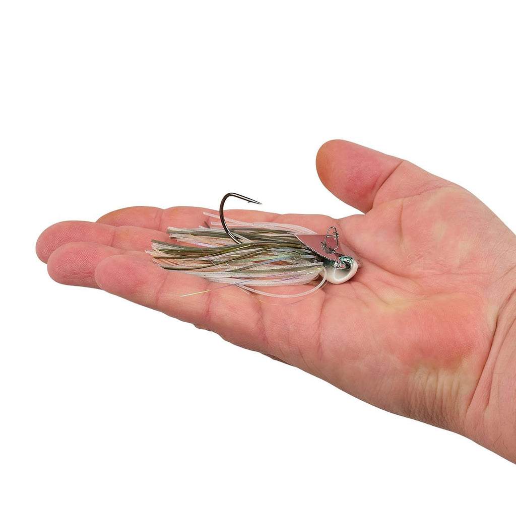 Bladed fishing jig in hand, silver head with multi-color skirt strands and curved hook