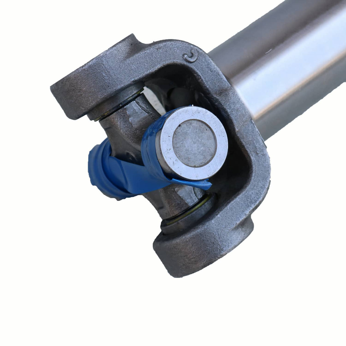 Close-up front drive shaft U-joint housing with blue boot and metal ring