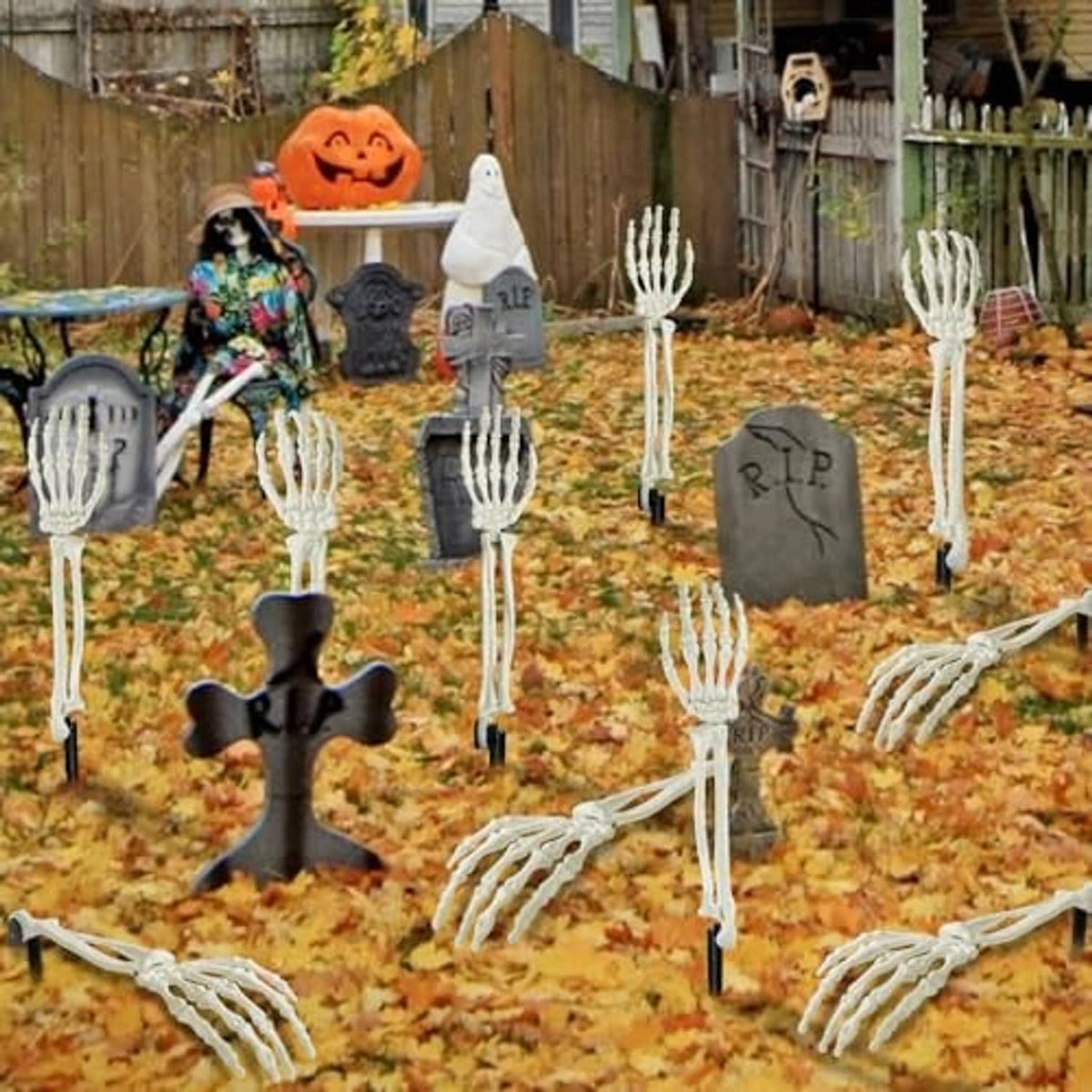 White skeleton hand stakes and arm skeleton pieces arranged in outdoor Halloween yard