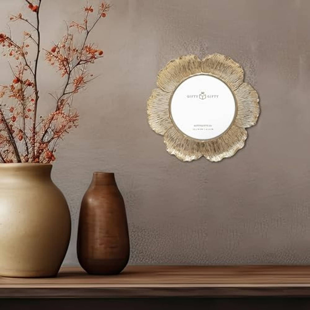 Gold circular floral photo frame with textured ridged border for tabletop display.