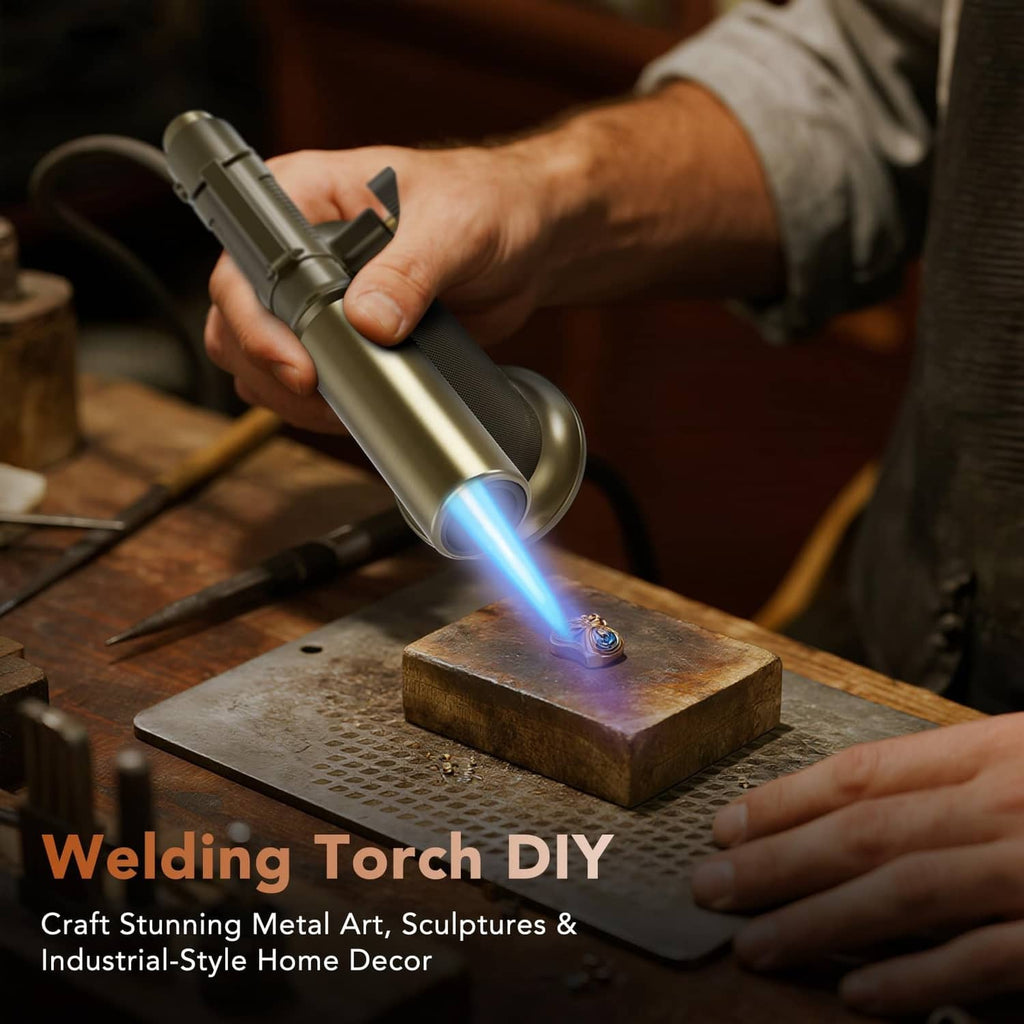 Gold butane torch aimed at metal workpiece, blue flame visible for welding