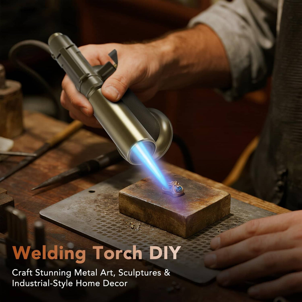 Gold butane torch aimed at metal workpiece, blue flame visible for welding