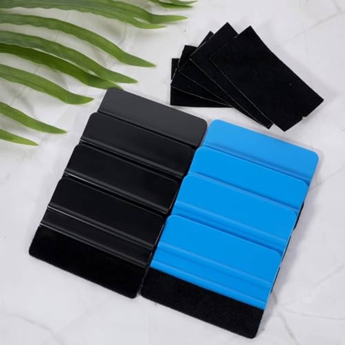 Blue and black vinyl squeegee pads with felt faces, arranged in two groups.