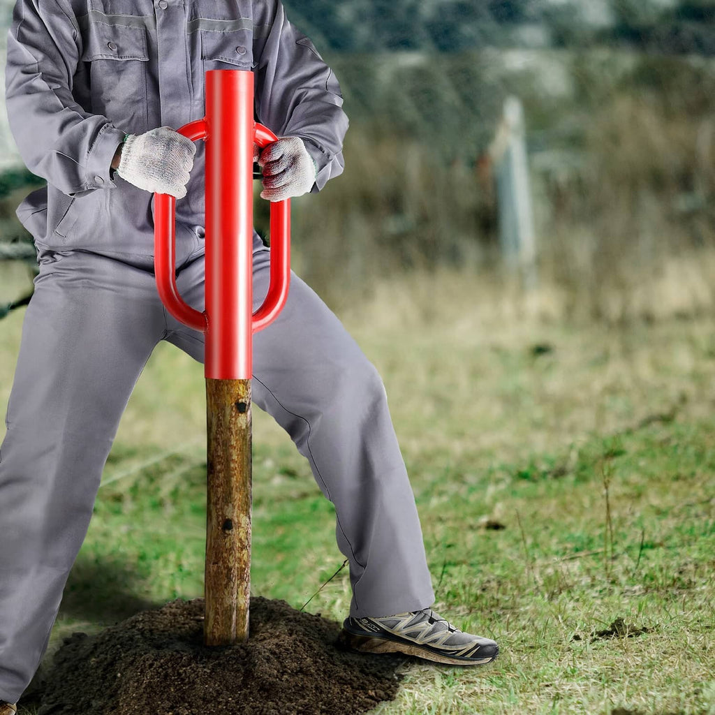 Red-handled fence post driver with U grips pounding a T-post into soil