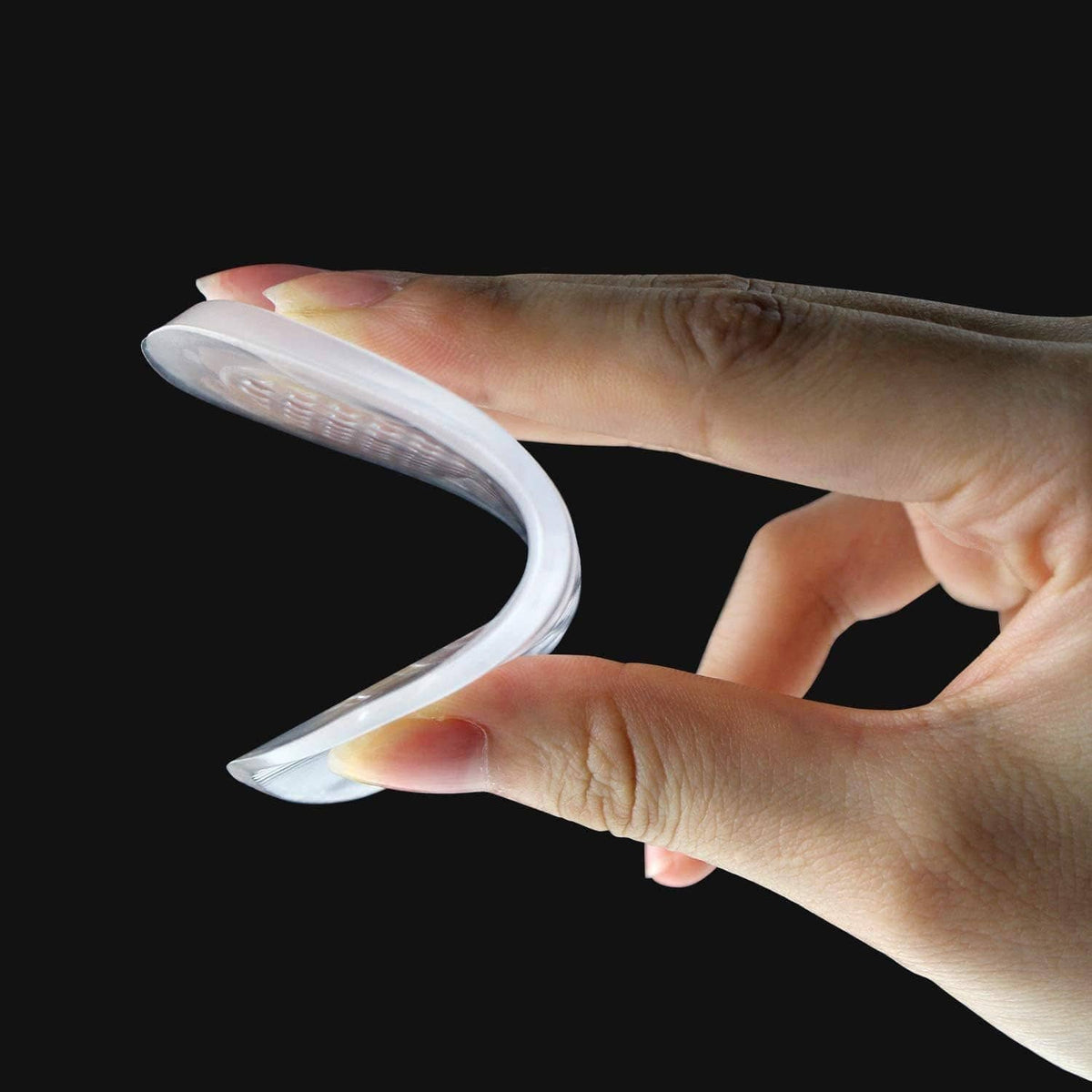 Silicone gel heel cups close-up in hands, shown over a bare foot