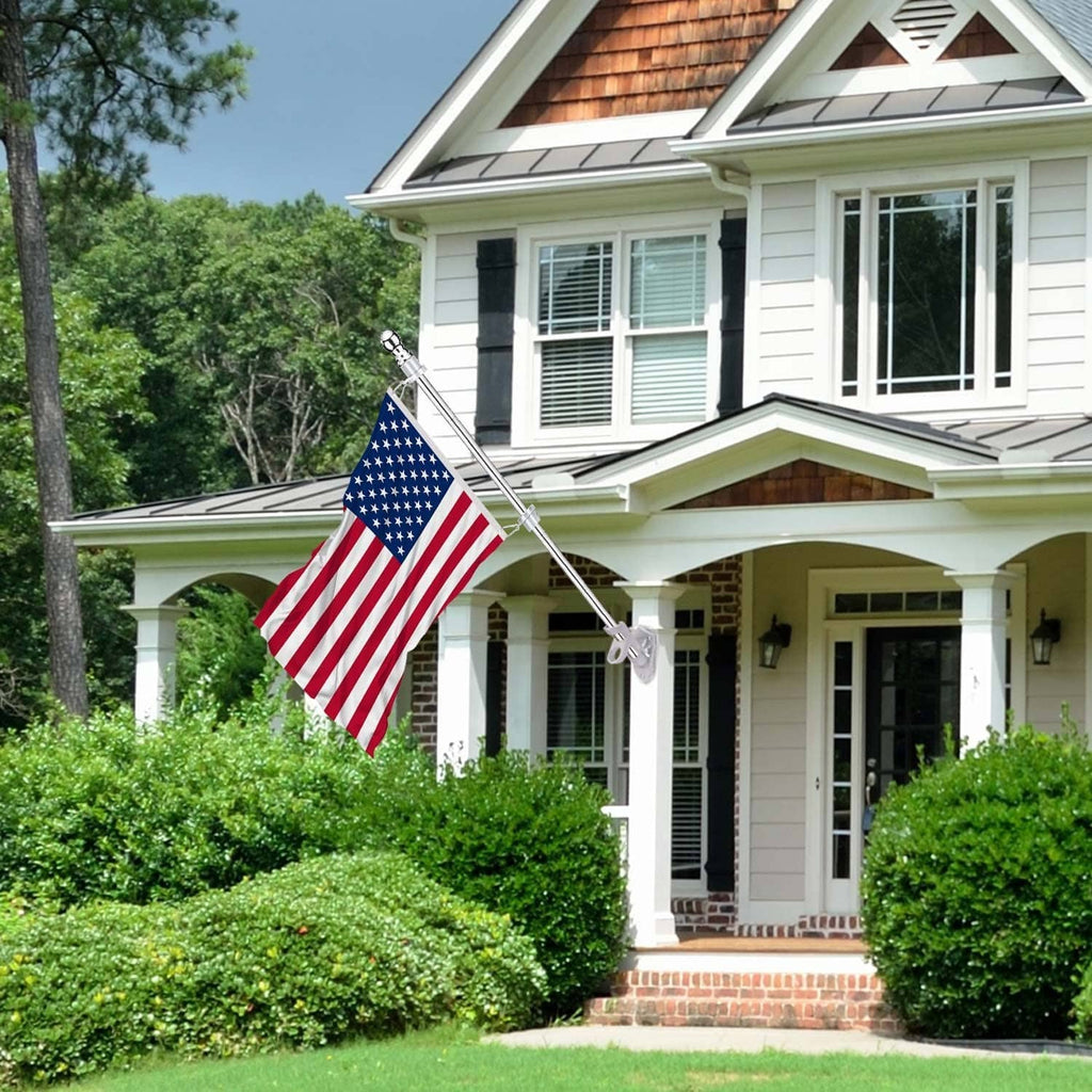 Silver flag pole holding an American flag outside a house entrance