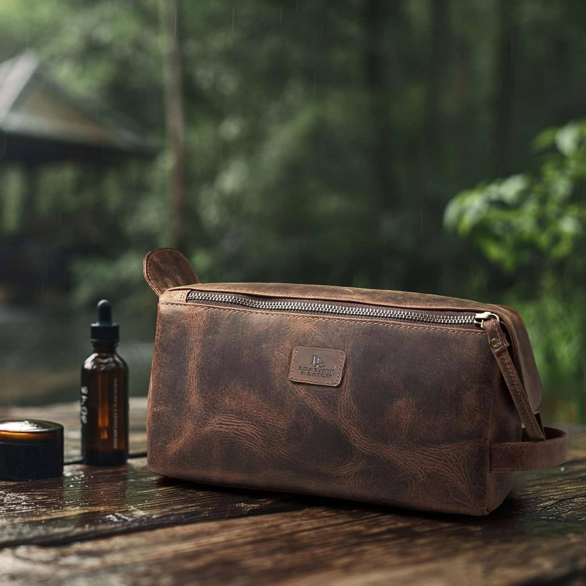 Brown leather toiletry bag with front double zippers and carry handle on outdoor table
