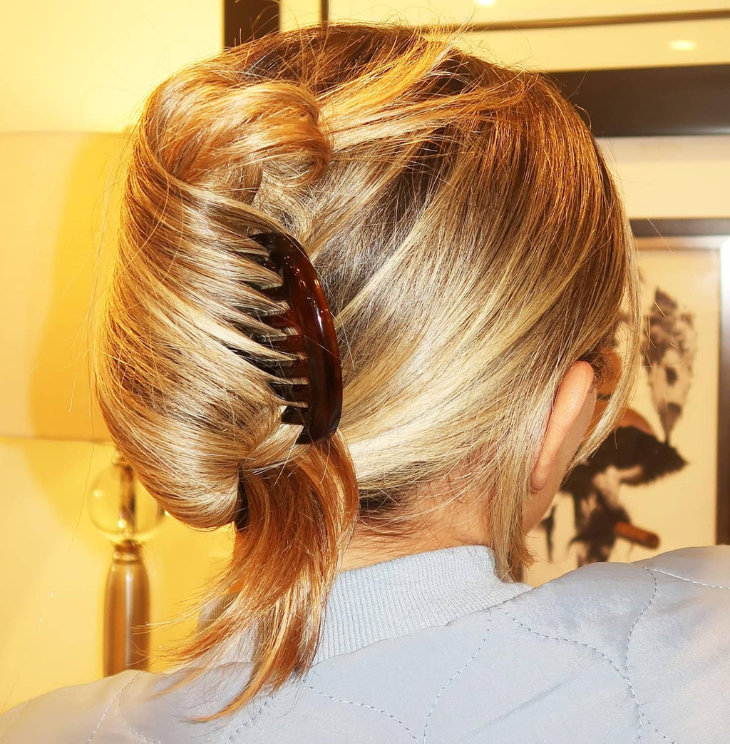 Tortoise shell side comb clipping a low bun hairstyle