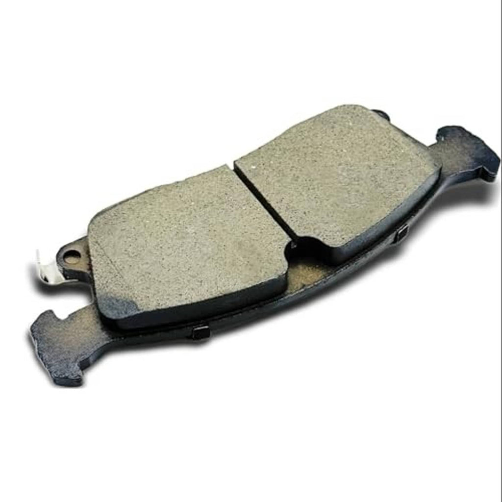 Ceramic brake pad with gray friction surface, angled view with metal ears