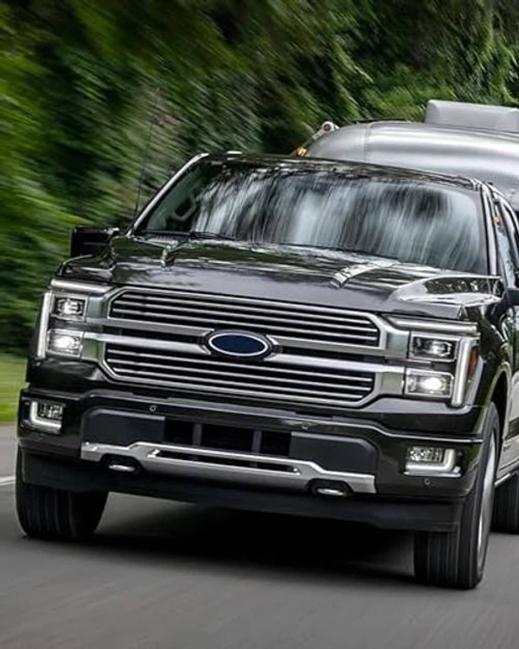 Black truck front grille with horizontal bars and oval blue center emblem