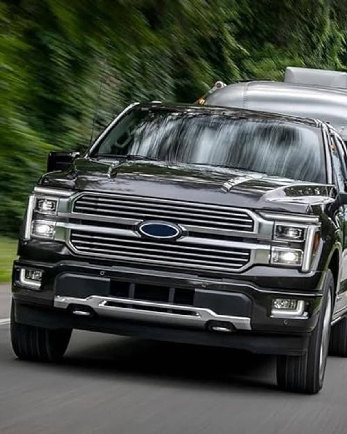Black truck front grille with horizontal bars and oval blue center emblem
