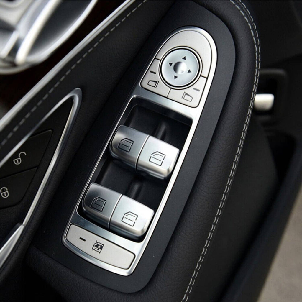 Power window switch panel with silver buttons and rotary control on black trim