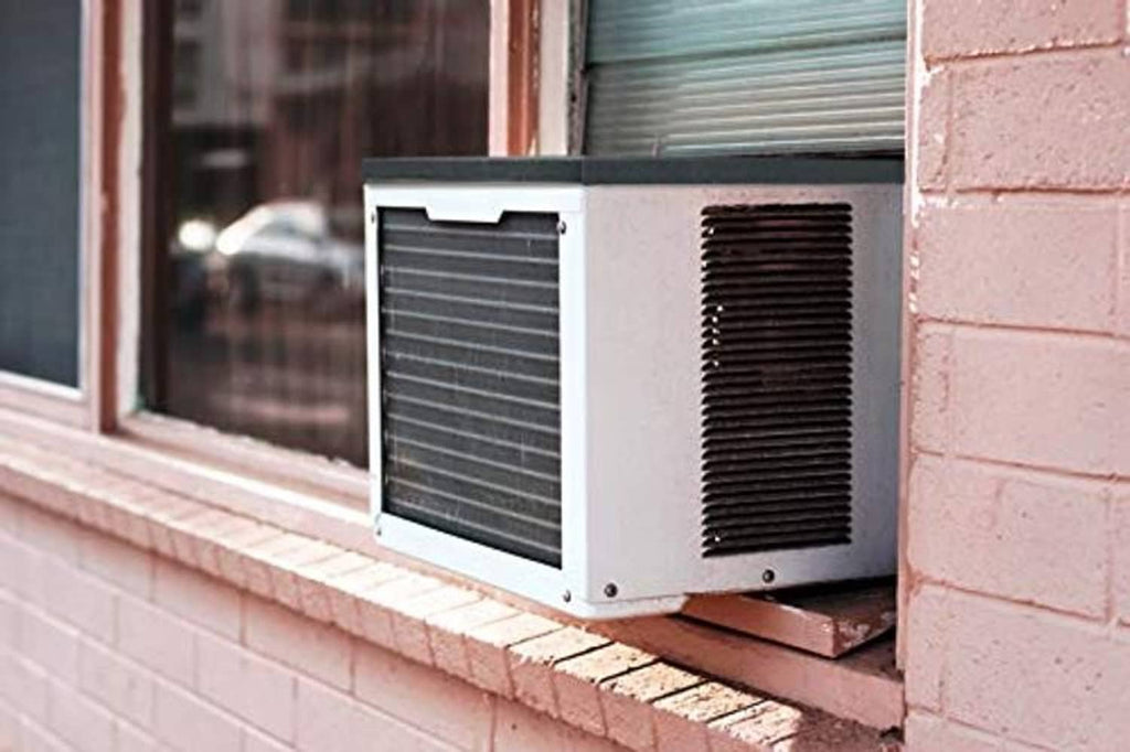 Dark gray/black AC rain cover pad installed under a window AC unit