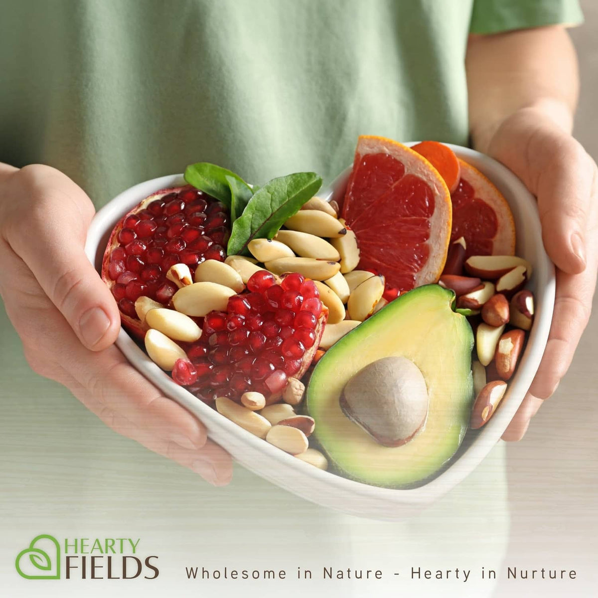 Bowl of assorted nuts, including brazil nuts, held in hands