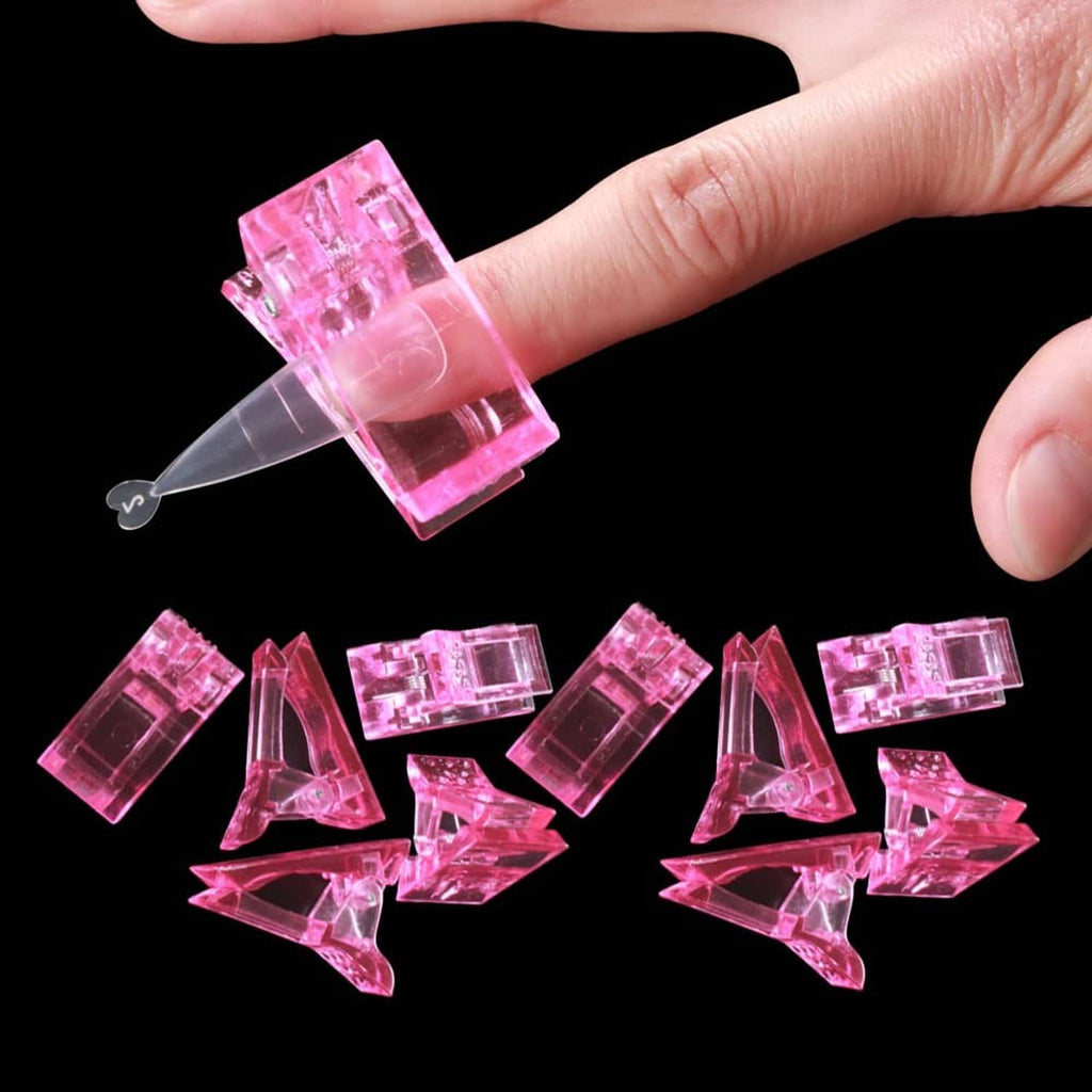 Pink nail tips clip held by fingers with a clear applicator tip