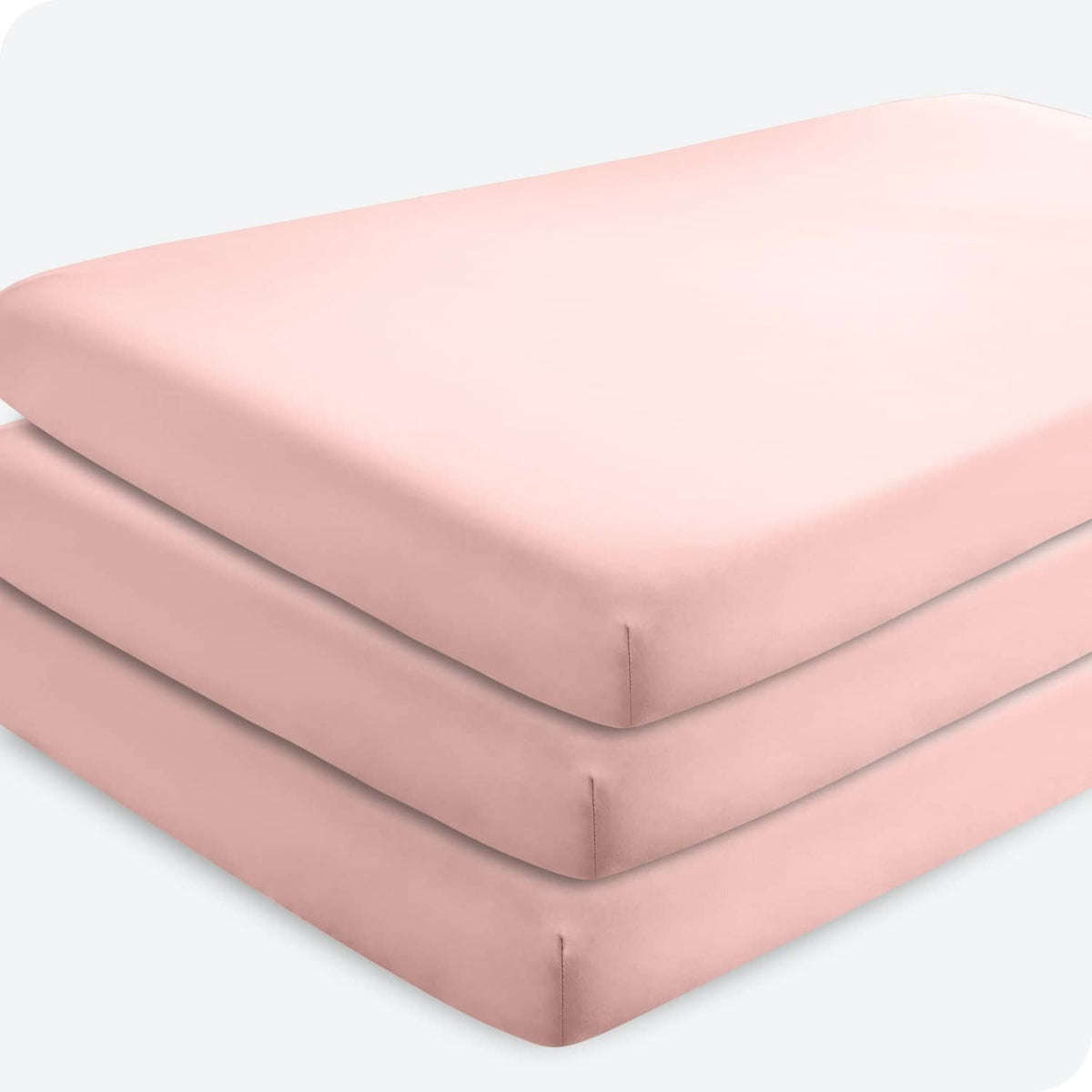 Pink crib fitted sheet set, layered view showing fitted corners and elastic edges