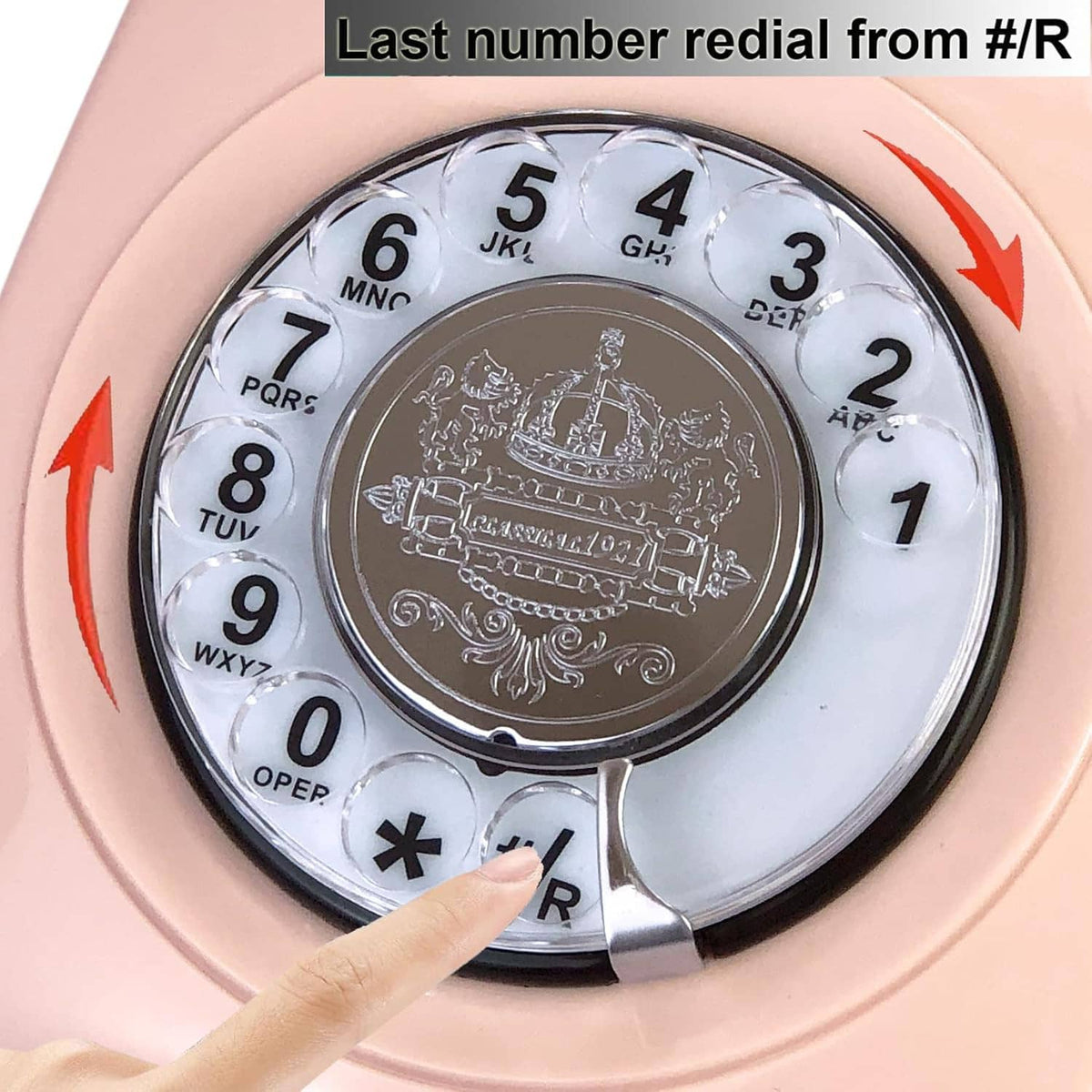 Close-up of pink rotary dial telephone showing number dial and handset hook switch