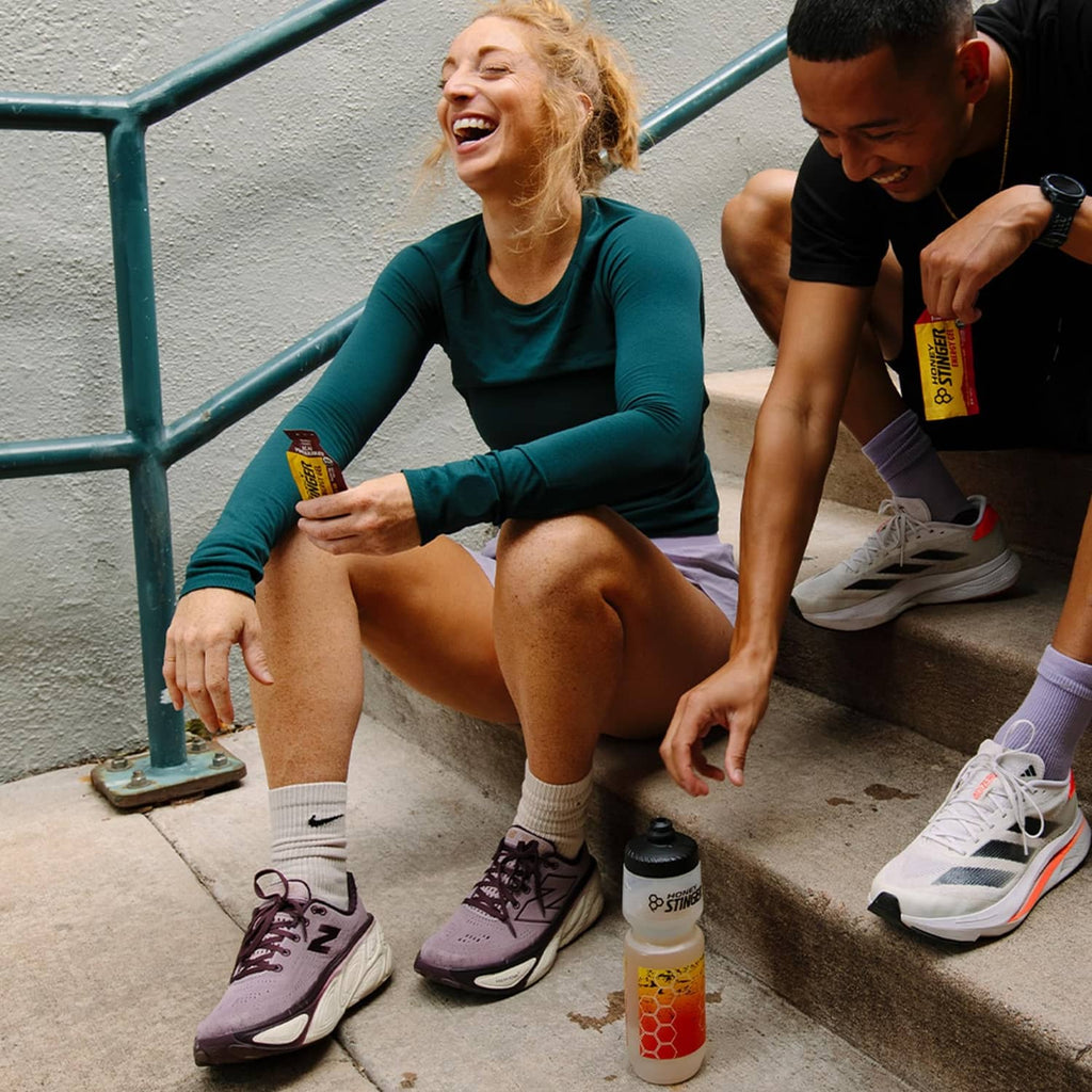 Acai pomegranate energy gel bottle and pouch sitting on steps