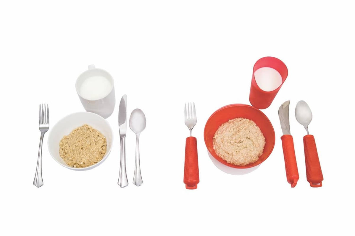 Red and white adaptive dinnerware set with plates, bowls, utensils, and cutout cup