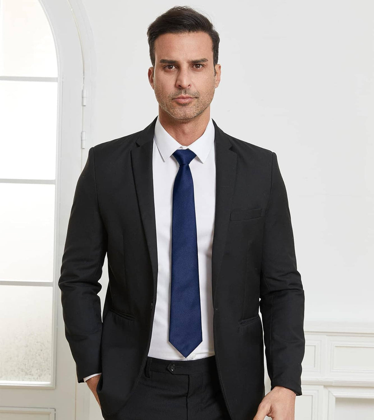Navy solid necktie worn with a white shirt and black suit jacket
