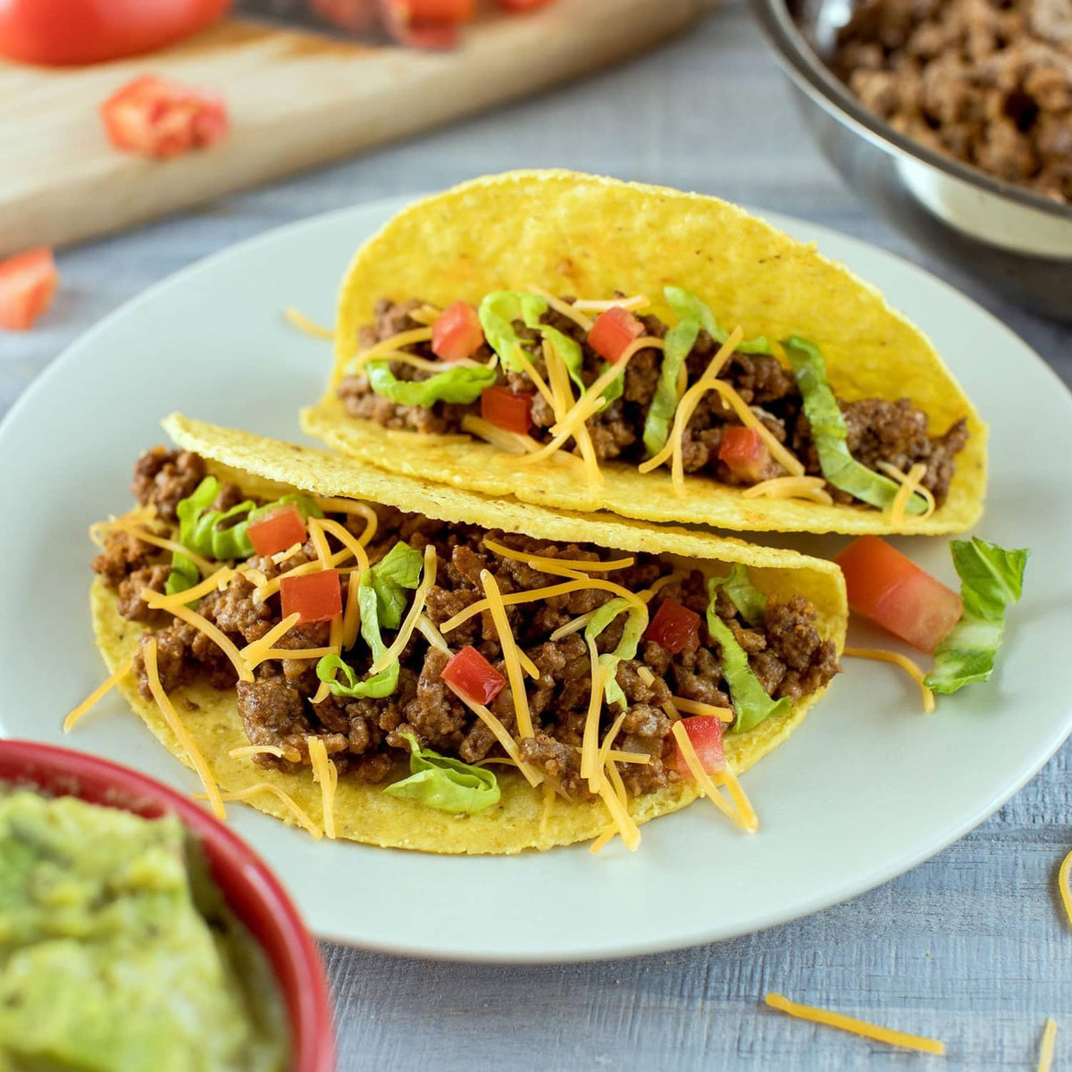 Taco shells filled with seasoned ground beef, topped with shredded cheese and lettuce