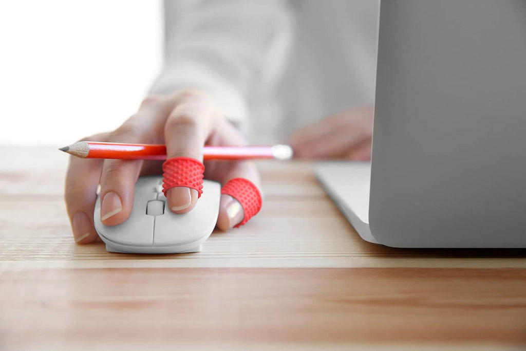 Red finger tip grips on hand using a computer mouse and writing