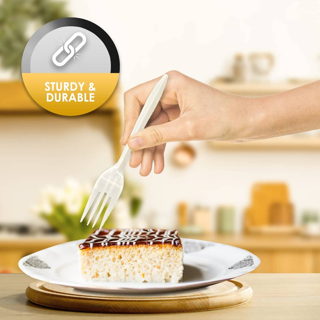 White disposable plastic fork held over a slice of cake