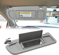 Light gray left driver sun visor with warning label and mounting bracket