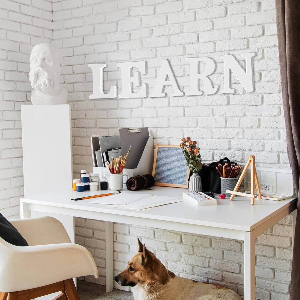 White unfinished wooden letters spelling LEARN above a craft desk