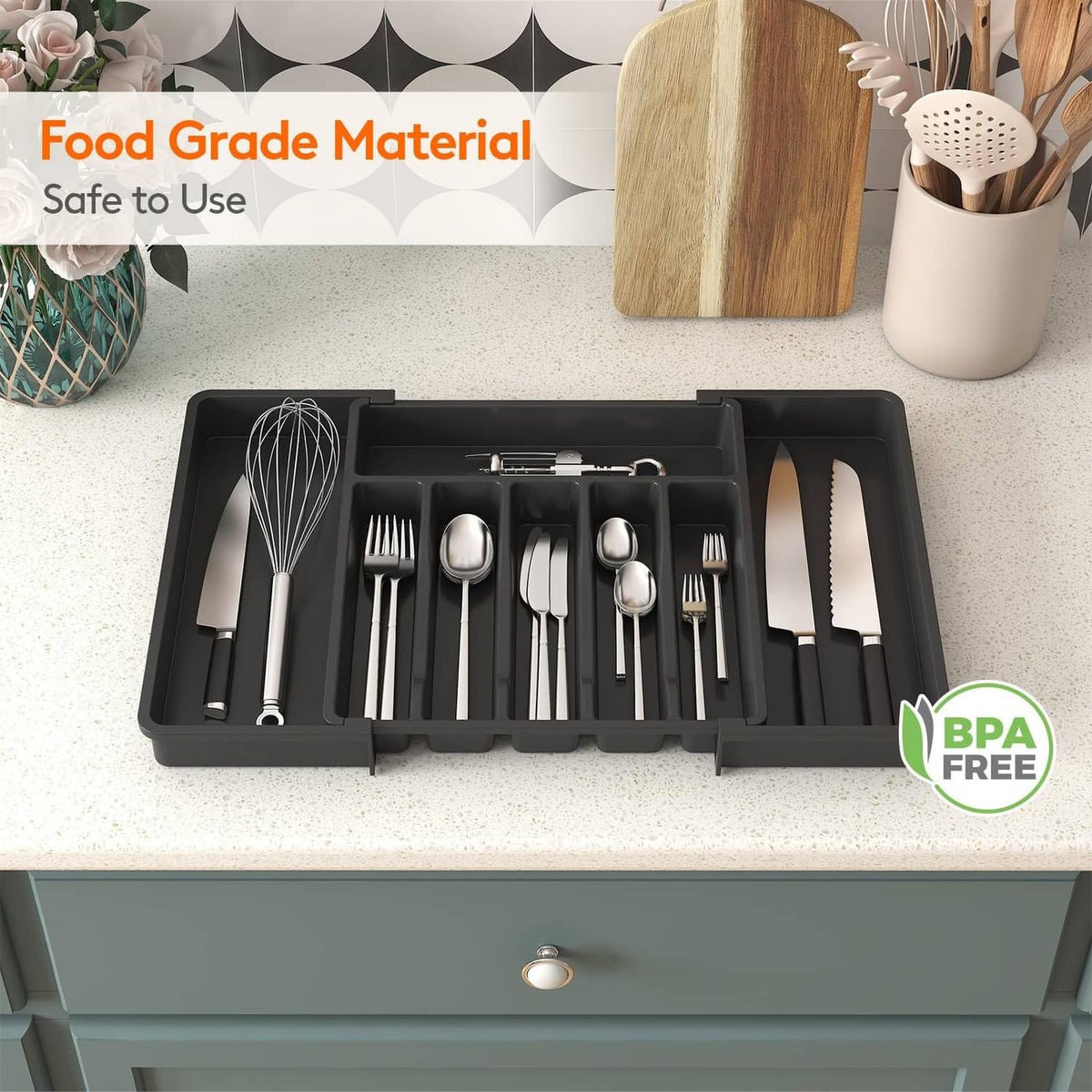 Dark utensil drawer organizer tray with cutlery arranged in separate compartments