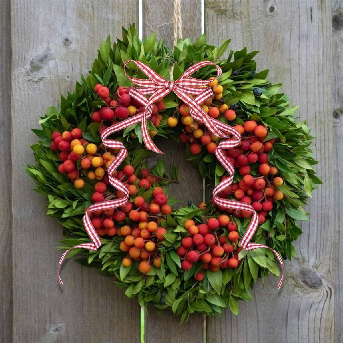 Red and white gingham ribbon bow on green wreath, thin striped ribbon for decoration
