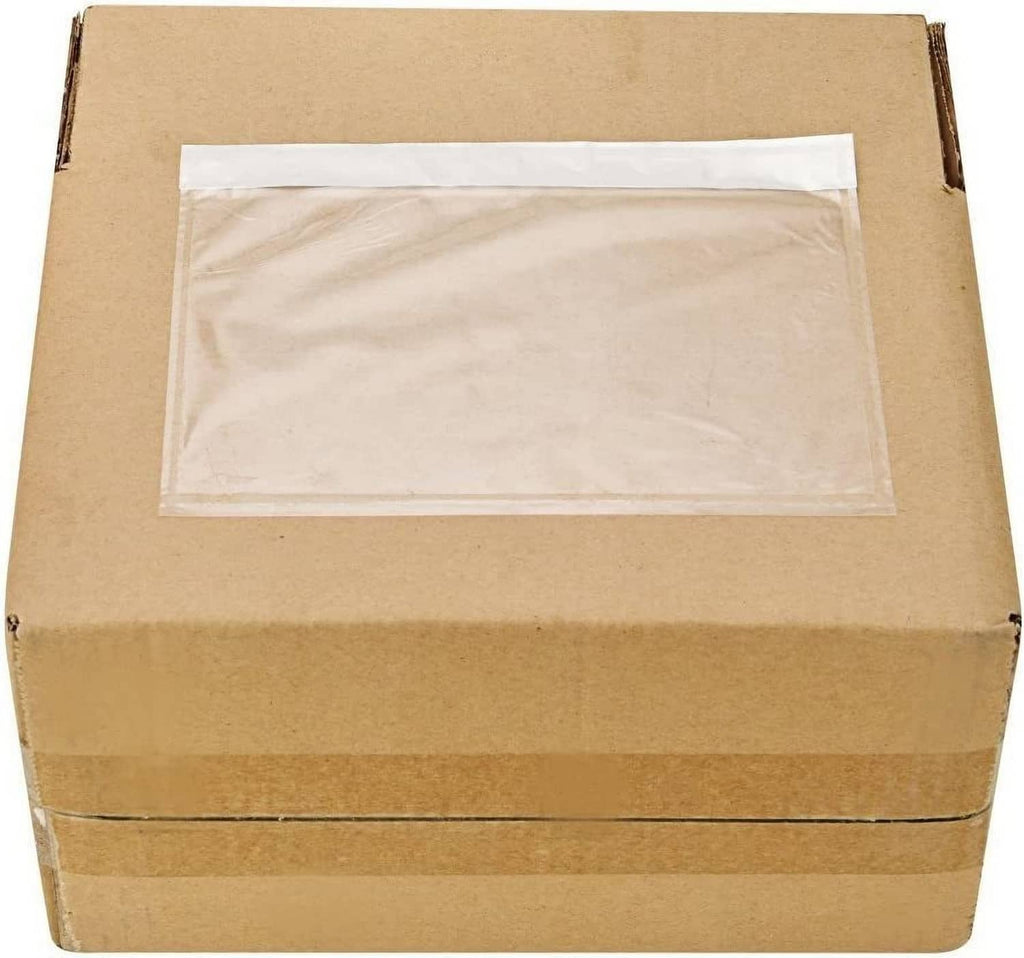 Clear adhesive top-loading packing list pouch, empty, on brown shipping box