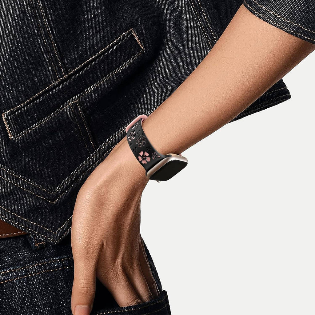 Floral engraved smartwatch band on wrist with black strap and pink flower pattern