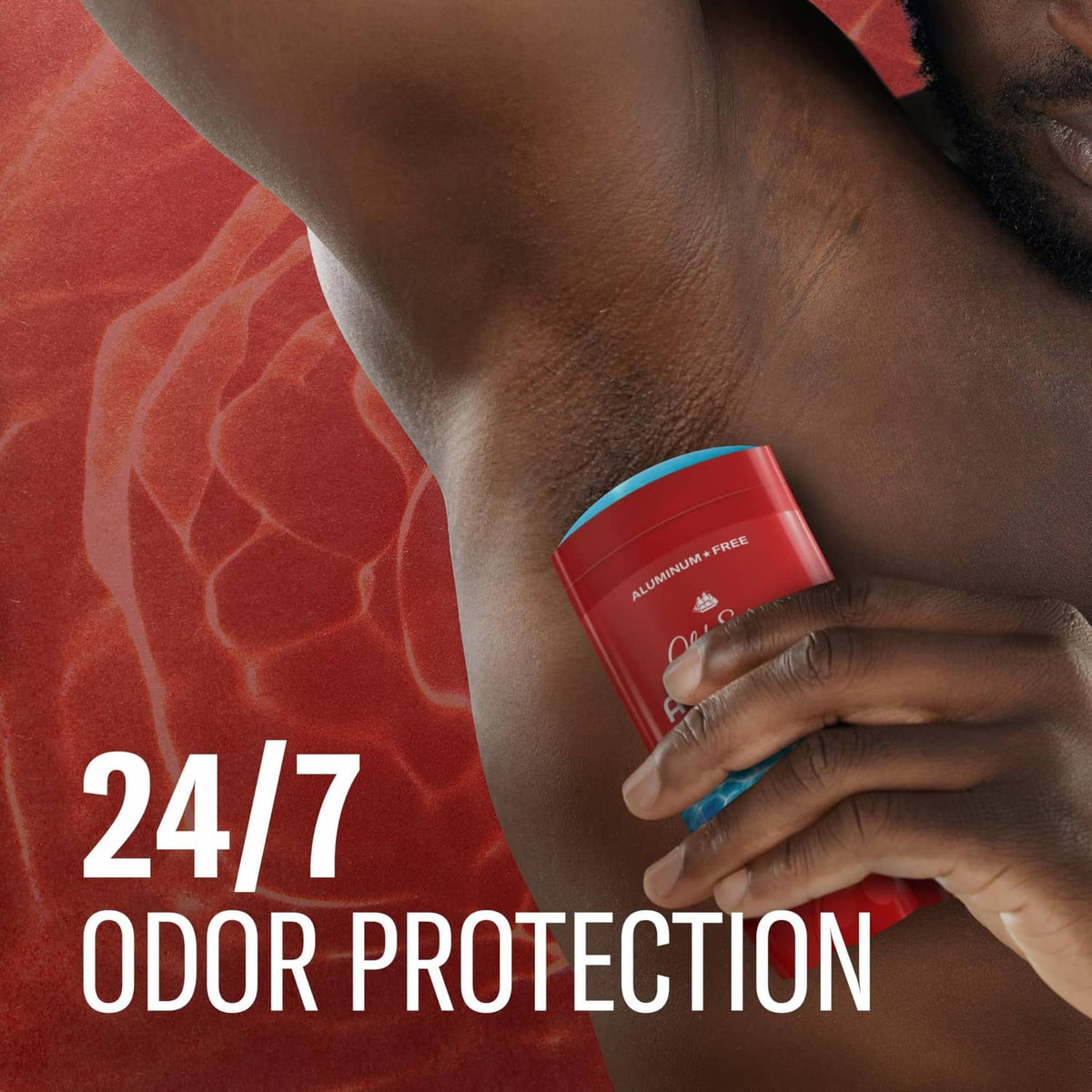 Old Spice Aqua Reef deodorant stick held in hand, red container with clear cap.