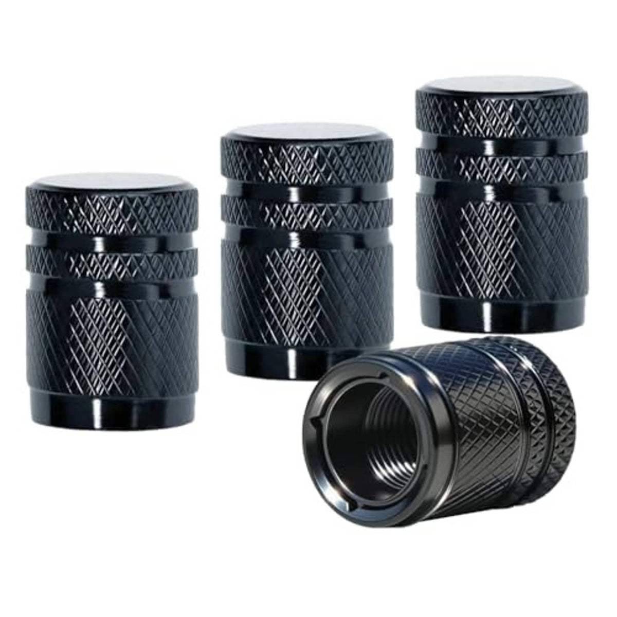 Four black textured tire valve stem caps, with one detached cap showing threaded opening