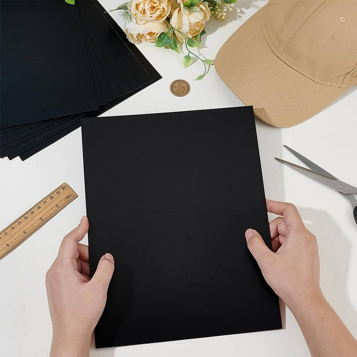 Black rectangular brim insert sheet held in hands, flat matte surface