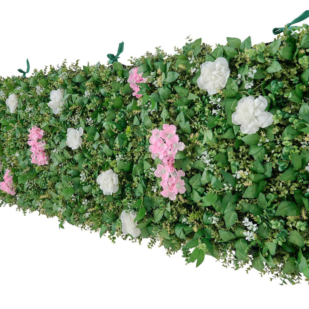 Artificial floral wall backdrop panel with dense green leaves and white/pink flowers