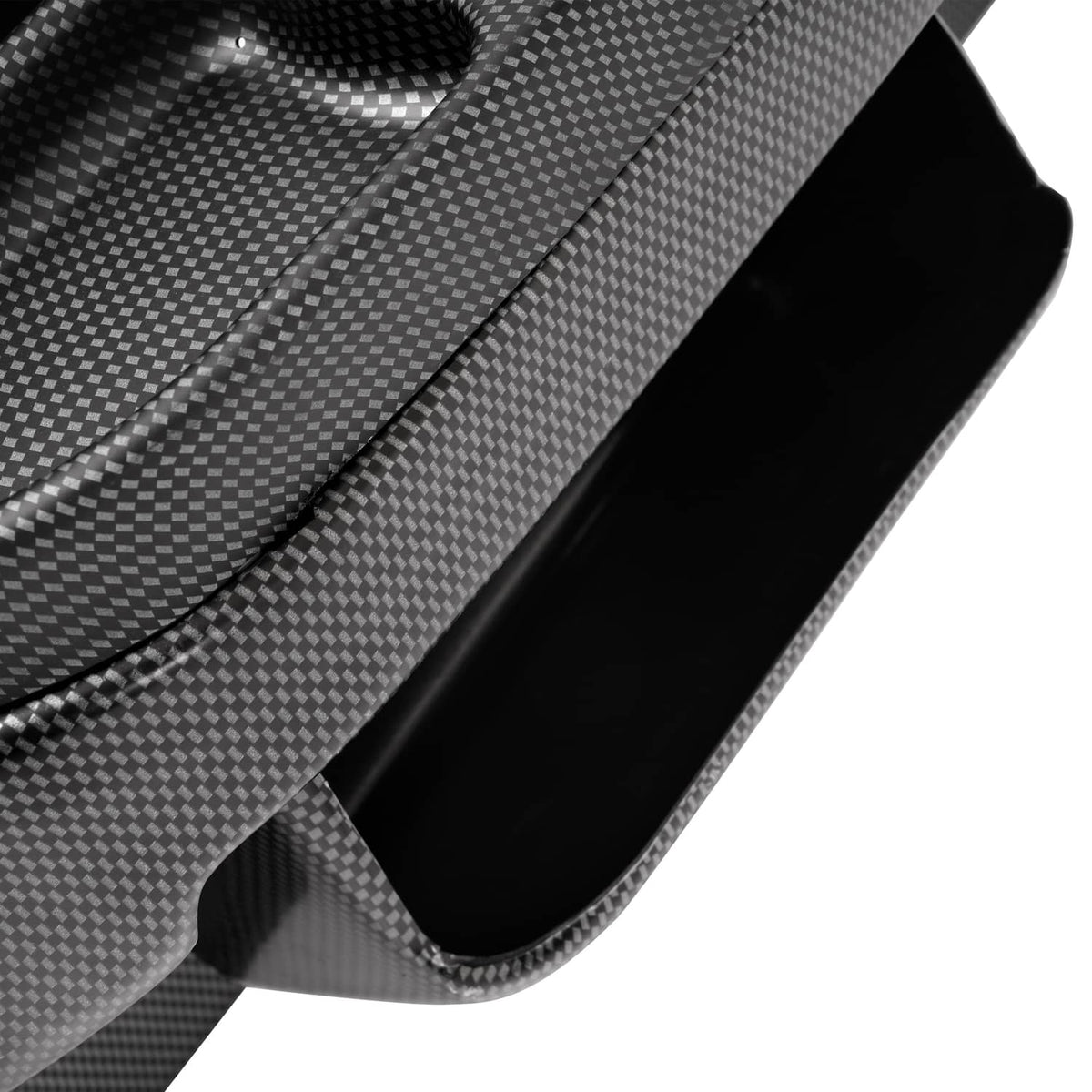 Close-up of carbon-fiber dash cover edge with a recessed side opening and smooth curved trim.