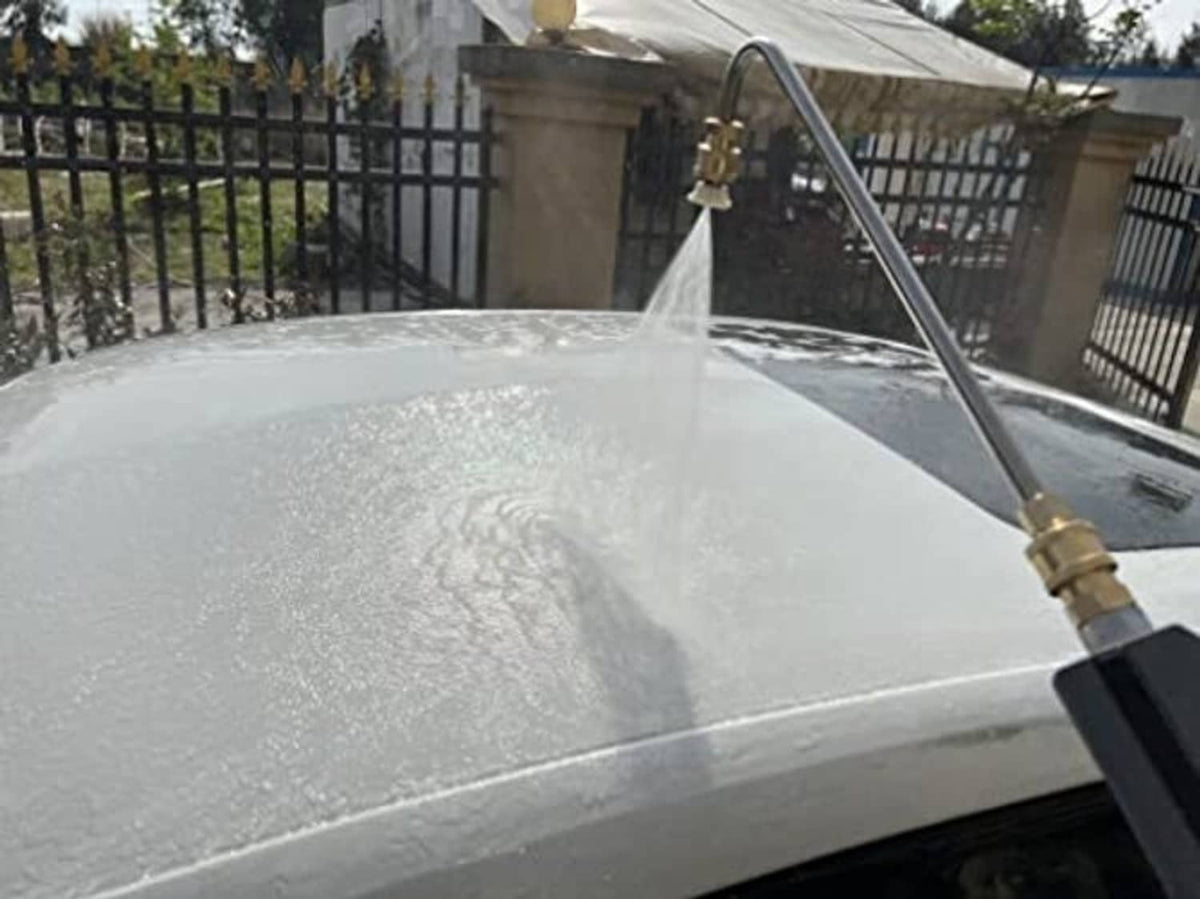 Angled pressure washer wand spraying water into a large round tank