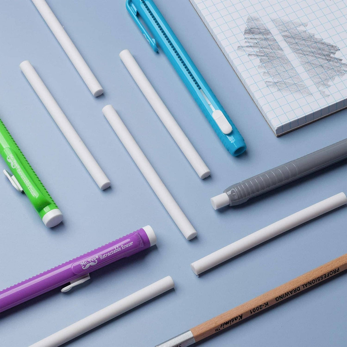 Assorted white eraser refill sticks with blue and green retractable pens on desk