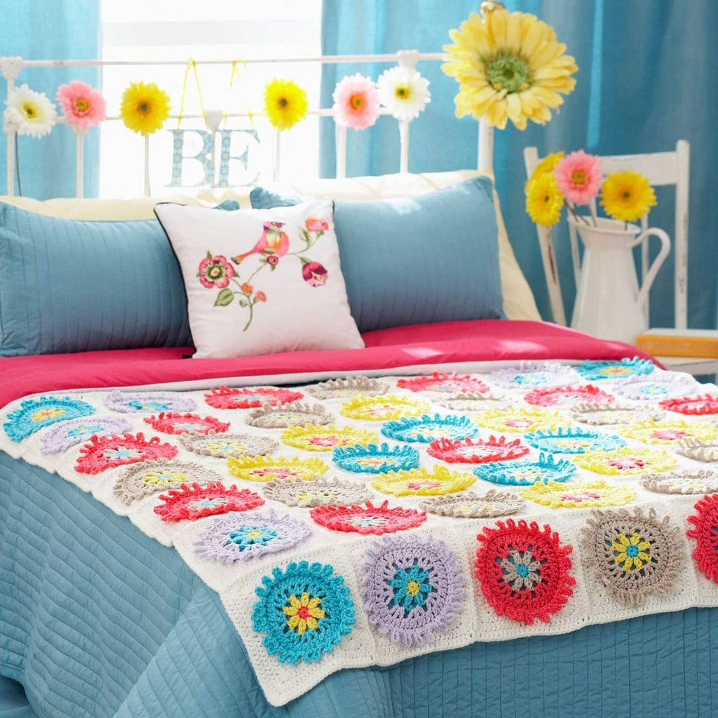 Crocheted blanket with multicolor flower motifs and scalloped edge