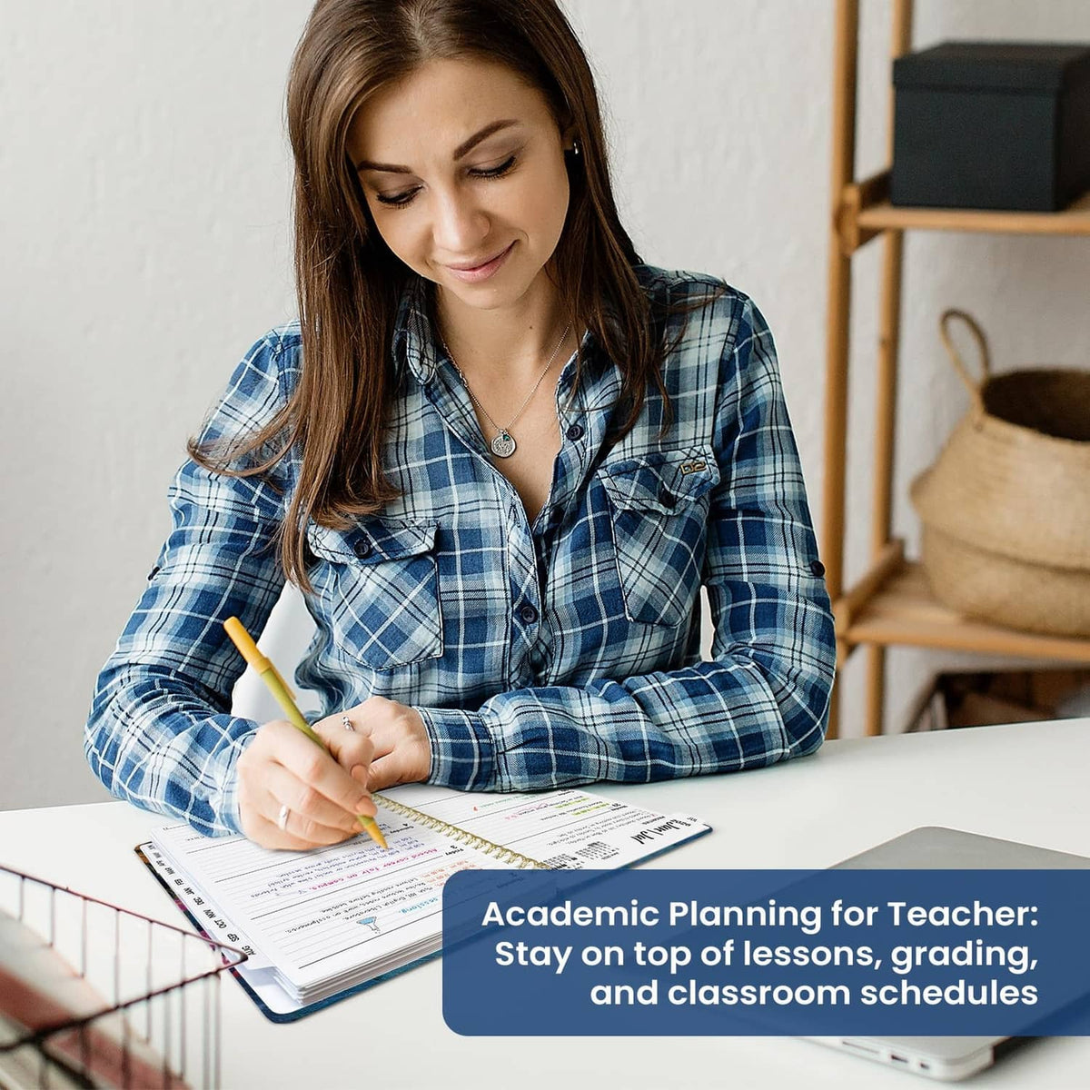 Teacher writes in open planner with date blocks, gold spiral binding visible
