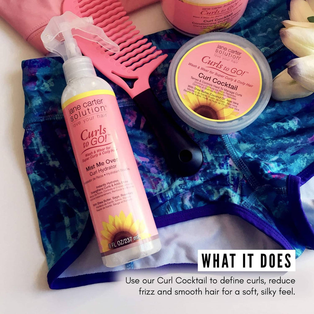 Curl Cocktail mist bottle and cream tub with pink labels near hair tools